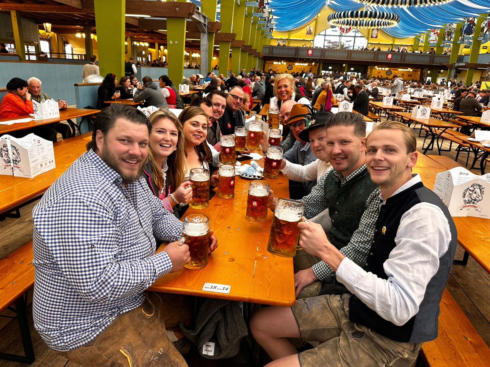 De groep proost aan een tafel vol Maß bier